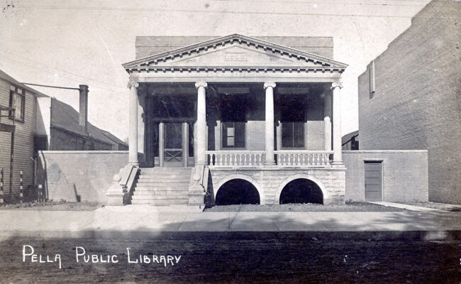A black and white photo of a library with the text "Pella Public Library" written in the corner.