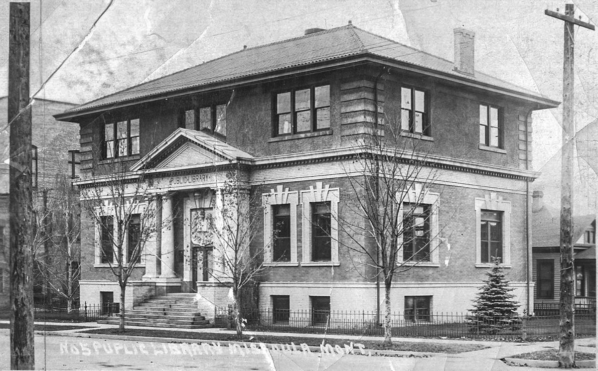 A black and white postcard of a square brick library with front columns