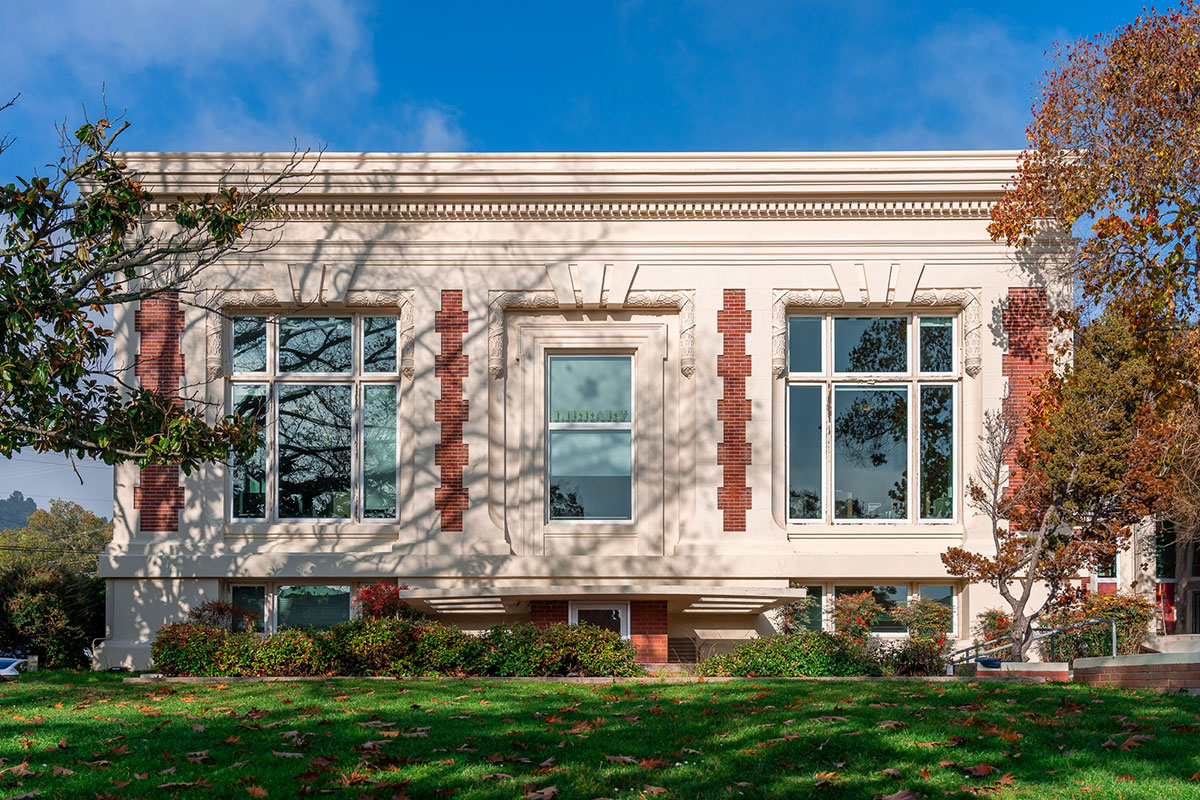 SR_DT_Library_2-(Reduced)---Catherine-Quffa A square library with windows, stone, and red brick, before trees.