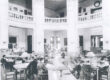 Black and white photo of a library interior with reading tables and high domed ceiling.