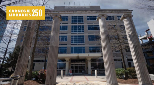 Stone columns stand out front of a modern building.
