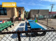 Colored wooden tables in a concrete yard behind a library
