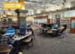People sit at computers in an open lab space in a library.