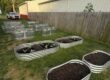 Titanium plant beds are arranged on grass, with soil and plants growing
