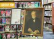 Portrait of Andrew Carnegie in front of library stacks